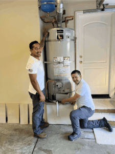 Tankless Guys plumbers next to their past repair projects.
